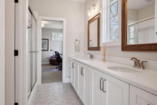 Shared 3/4 bath offers double sinks, walk-in shower, and great storage