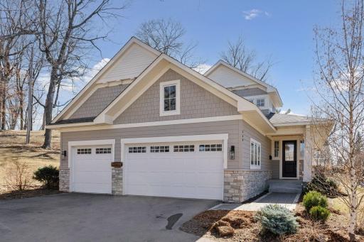Charming curb appeal with shake, wood, and stone siding, along with architectural details and pretty landscaping