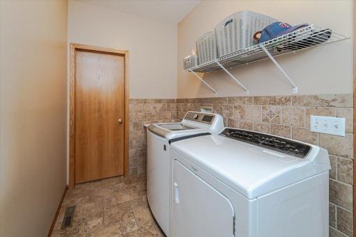 The main floor laundry room has a tile backsplash and floor, as well as a walk-in closet.