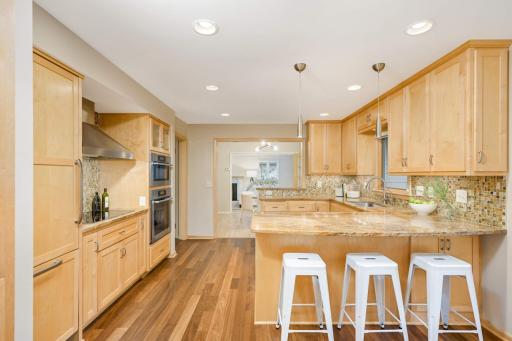 The amazing remodeled kitchen boasts maple cabinets, granite countertops & tiled backsplash