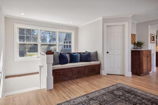 Bright and airy mudroom with bench seating and coat closet.