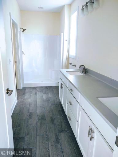 Owners bathroom- double bowl sinks, tiled floors, walk in closet and step in shower