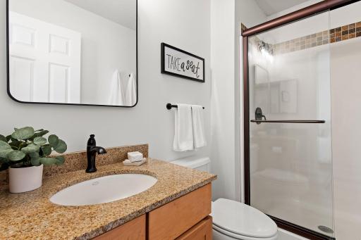 Three-quarter primary bath has updated shower and new lighting, mirror and hardware.