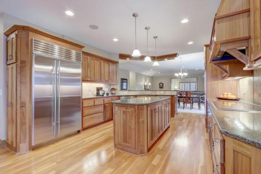 Prepare culinary delights in the immaculate kitchen, boasting an abundance of storage, a center island, sparkling granite countertops, tile backsplash, double wall oven, and stainless steel appliances.