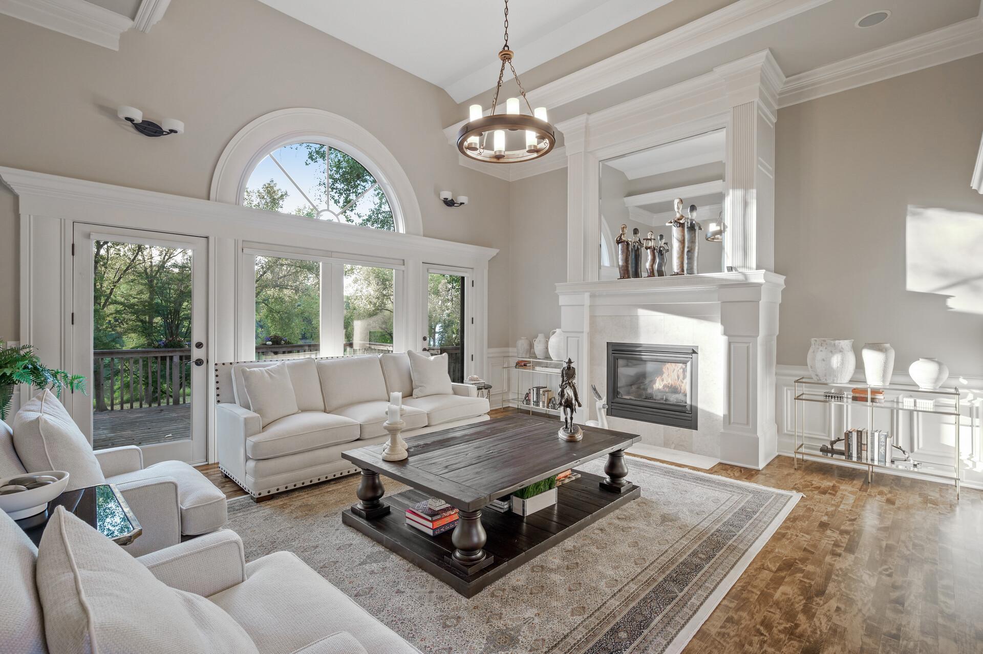 Architectural arches beckon you into the main level's great room, where large picture windows frame breathtaking views and provide easy access to the deck. A cozy gas fireplace creates an inviting focal point.