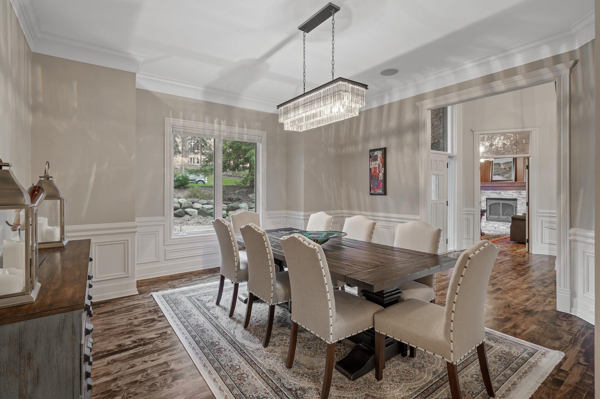 Entertain in style in the adjacent formal dining room, adorned with a trendy chandelier and extended wainscoting, creating an atmosphere of refined sophistication.
