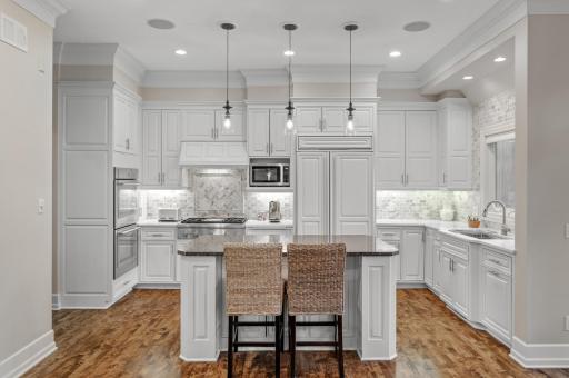 The gourmet kitchen is a chef's dream, boasting custom cabinetry, integrated appliances, and pristine finishes.