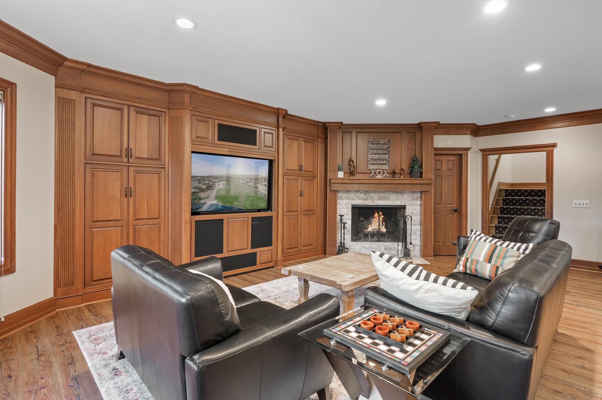 Offering a cozy family room with a built-in entertainment center and a bar with seating.