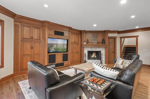 Offering a cozy family room with a built-in entertainment center and a bar with seating.