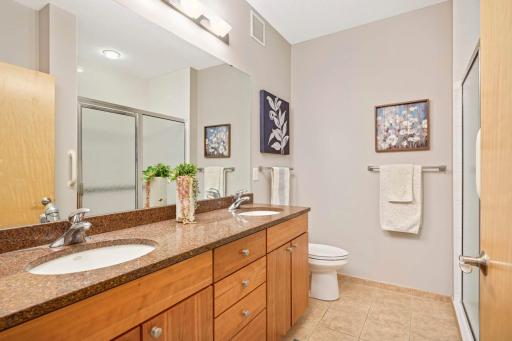 Owners suite bathroom features granite tops, double sinks, large linen, ceramic tile floors and walk in shower with grab bars.