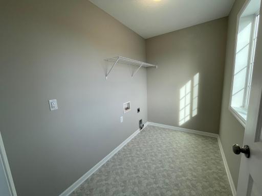 Spacious upper level laundry room includes a window offering natural light.