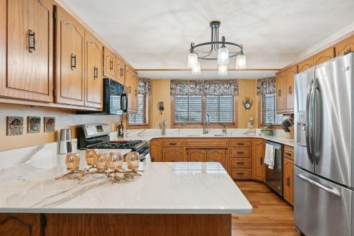The kitchen features plenty of storage, new porcelain/quartz mix countertops, light fixture, and stainless steel appliances.