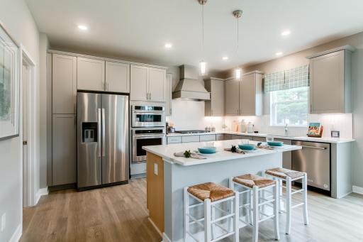 Quartz countertops and stunning backsplash in this gourmet kitchen! Welcome to the family chef's dream kitchen!! (Photo of model, colors may vary)