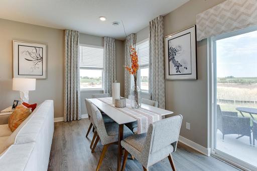 The home's dining area is large enough to fit just about any table and seating arrangement - and provides easy access out to the grilling space off the back!! (Photo of model, colors are similar)