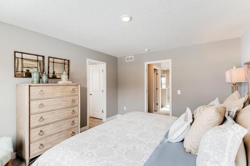 A second view of the Primary Suite, seen here with a King sized bed and the access point to the room's Primary bathroom!! (Photo of same plan, colors are similar)