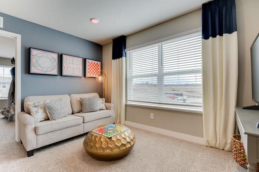 The primary suite is off the back of the home. This space (the home's loft) resides just atop the stairs and offers that second living space families of all sizes have come to appreciate! (Photos of the same floorplan, colors are similar)