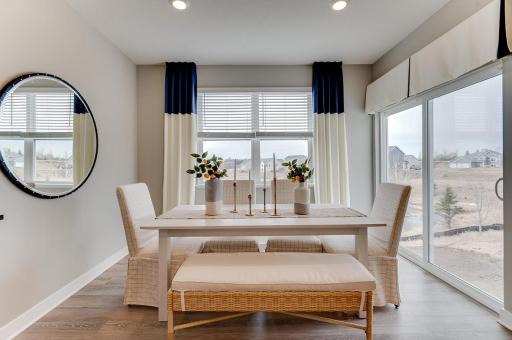 Tucked off the kitchen is the home's dining space - which resides just adjacent to door to rear of home (Photos of the same floorplan, colors may vary).