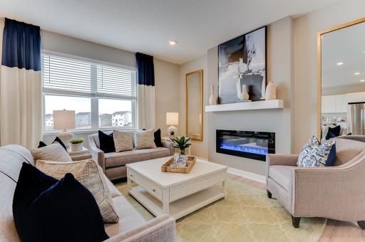 Soaring windows shed light on a main level living space that is large enough to handle most furniture set-ups and features a contemporary electric fireplace and mantle combination! (Photos of the same floorplan, colors are similar)