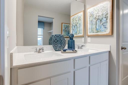 Connected to the primary suite is this bathroom, which includes a double-vanity, stand-in shower and serves as the passage way to the bedrooms oversized walk-in closet!! (Photos of the same floorplan, colors may vary).