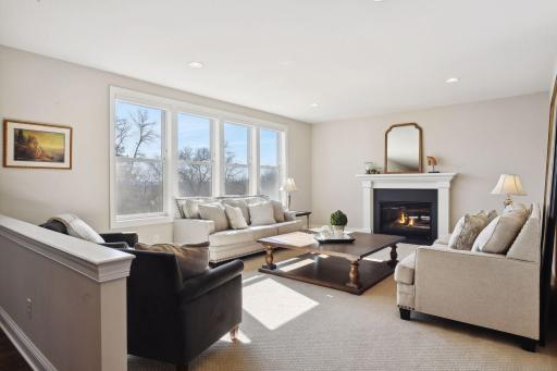 The spacious great room is embellished with a wall of windows basking the home in sunlight.