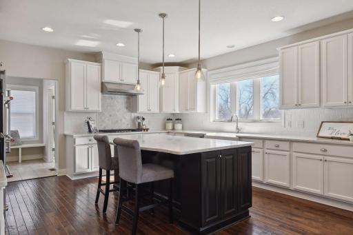 The kitchen is a chef's dream with an abundance of countertops, custom cabinetry and island, perfect for gathering.