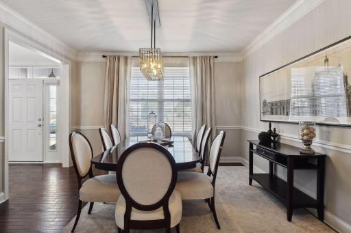 Upon entering the home, be greeted by this alluring dining space with crown molding and stunning lighting.