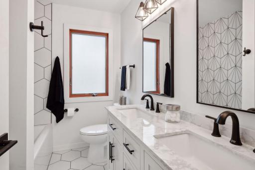 Gorgeous new double sink vanity, tile, and lighting in your full bathroom