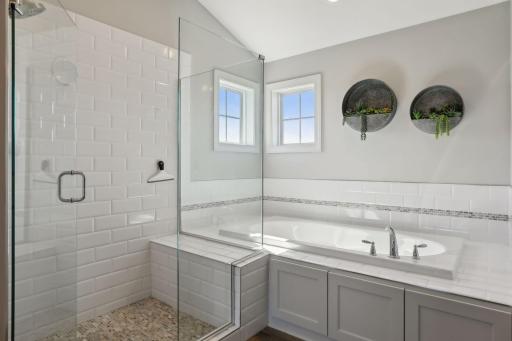 Separate tub, full glass shower with mosiac tile, private water closet and walk-in closet included in this bathroom area.
