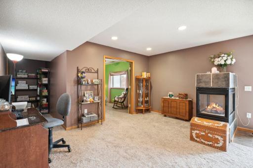 Basement rec area with gas fireplace leading to bedroom