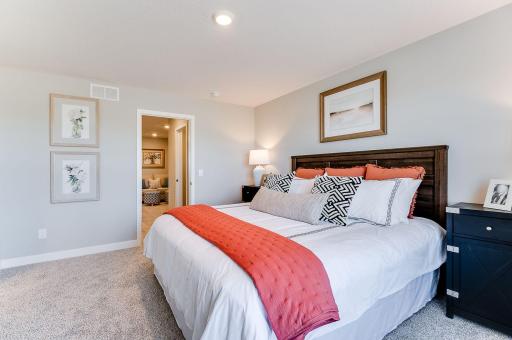 Beautiful primary bedroom upstairs with private ensuite bathroom and walk-in closet. Photo of model home, color & options will vary.