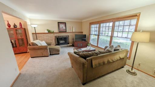 Step inside and a spacious and bright living room awaits, complete with a wood-burning fireplace with natural stone