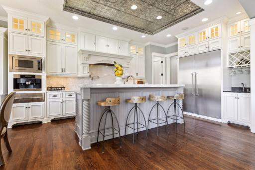 Impressive gourmet kitchen with enameled cabinets, high end stainless steel appliances, built-in espresso machine, warming drawer, & marble countertops.