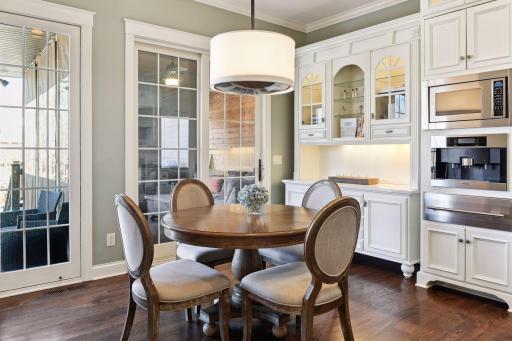 Informal dining area with built-in buffet hutch and walls of windows overlooking private backyard.