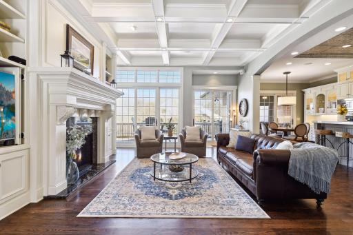 WOW! Great room boasts coffered ceilings, floor to ceiling windows leading to the deck and backyard.