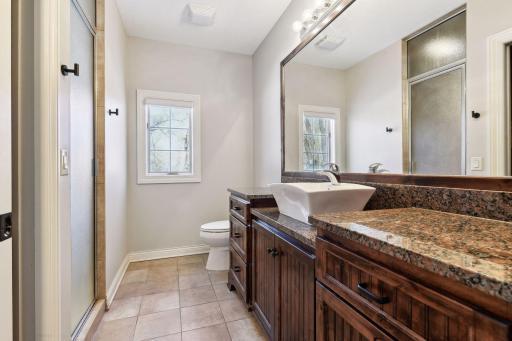 Plenty of counterspace, tile floors, granite countertops, & shared walk-through shower.