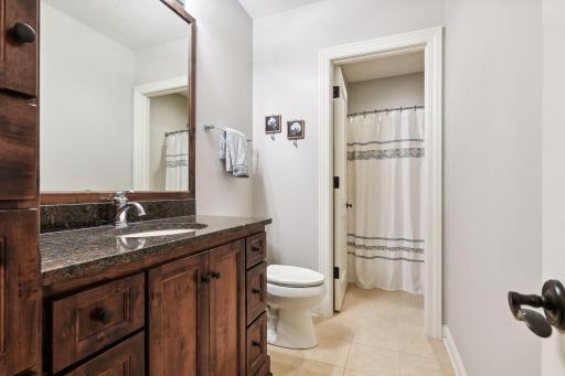 Ensuite bathroom can be accessed from main family room area. Offering a tub/shower combination, tile floors, and custom vanity.