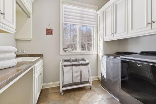 Main floor huge laundry room with utility sink, folding area, and fantastic storage.