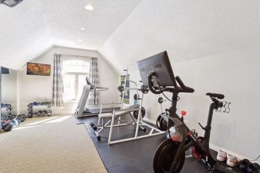 5th bedroom with closet, currently being used as an exercise room. Access to huge additional storage area that could be finished to create separate living quarters with kitchenette. Stairs down to garage as well.