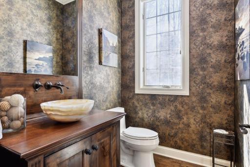 Distinguished main floor powder room with custom built-in vanity and mirror.