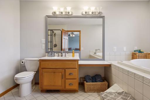 Owner's private full bath has a tile floors, jetted tub, and separate tile shower.