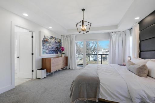 High-end primary bedroom on suite with custom drapes.