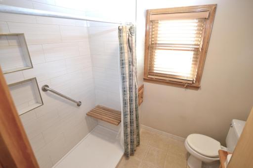 Upper level bath with walk in shower with tile surround