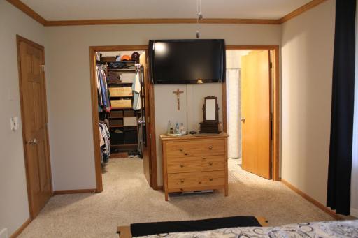 View into walk-in closet and private bathroom in the primary bedroom.