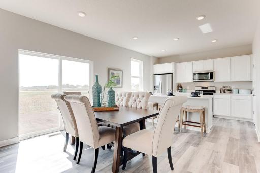 Sun-soaked dining space provides a great space for conversation and good food. *Photo is of model home. Actual finishes may vary.