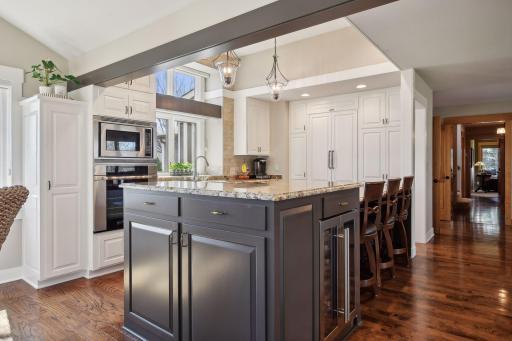 Beautiful kitchen island has a breakfast bar area and wine cooler