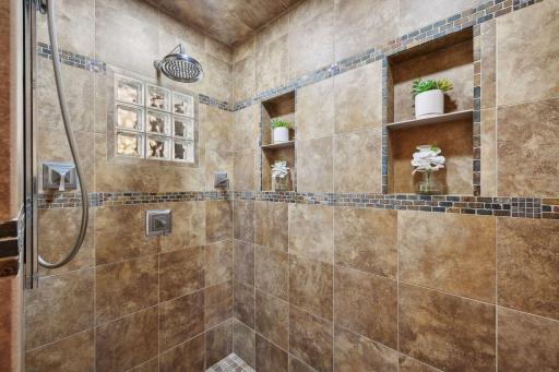 The gorgeous walk-in shower was thoughtfully designed with extra inset shelving