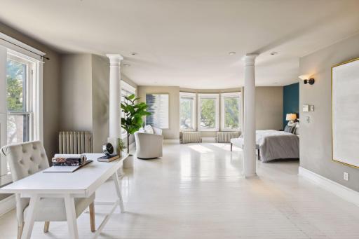 Bathed in natural light, this expansive primary suite becomes a haven of warmth and serenity.