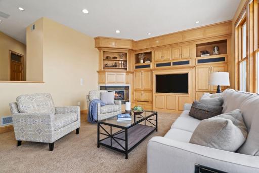 Relax in the expansive living room, complete with a cozy gas-burning fireplace, built-ins, and stunning backyard views, providing an inviting space for relaxation and entertainment.