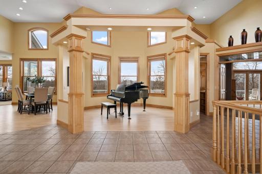 Foyer leads to the piano room, offering serene backyard views through a bay window.