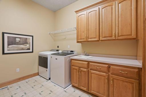 Enjoy the convenience of a well-appointed laundry room on the main level, complete with cabinetry and a utility sink, making laundry tasks a breeze.